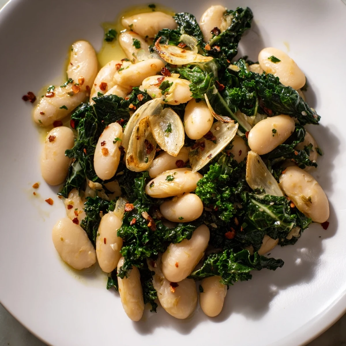 Golden garlic infuses this vibrant Garlicky Beans with Winter Greens, a healthy, flavorful Mediterranean meal.