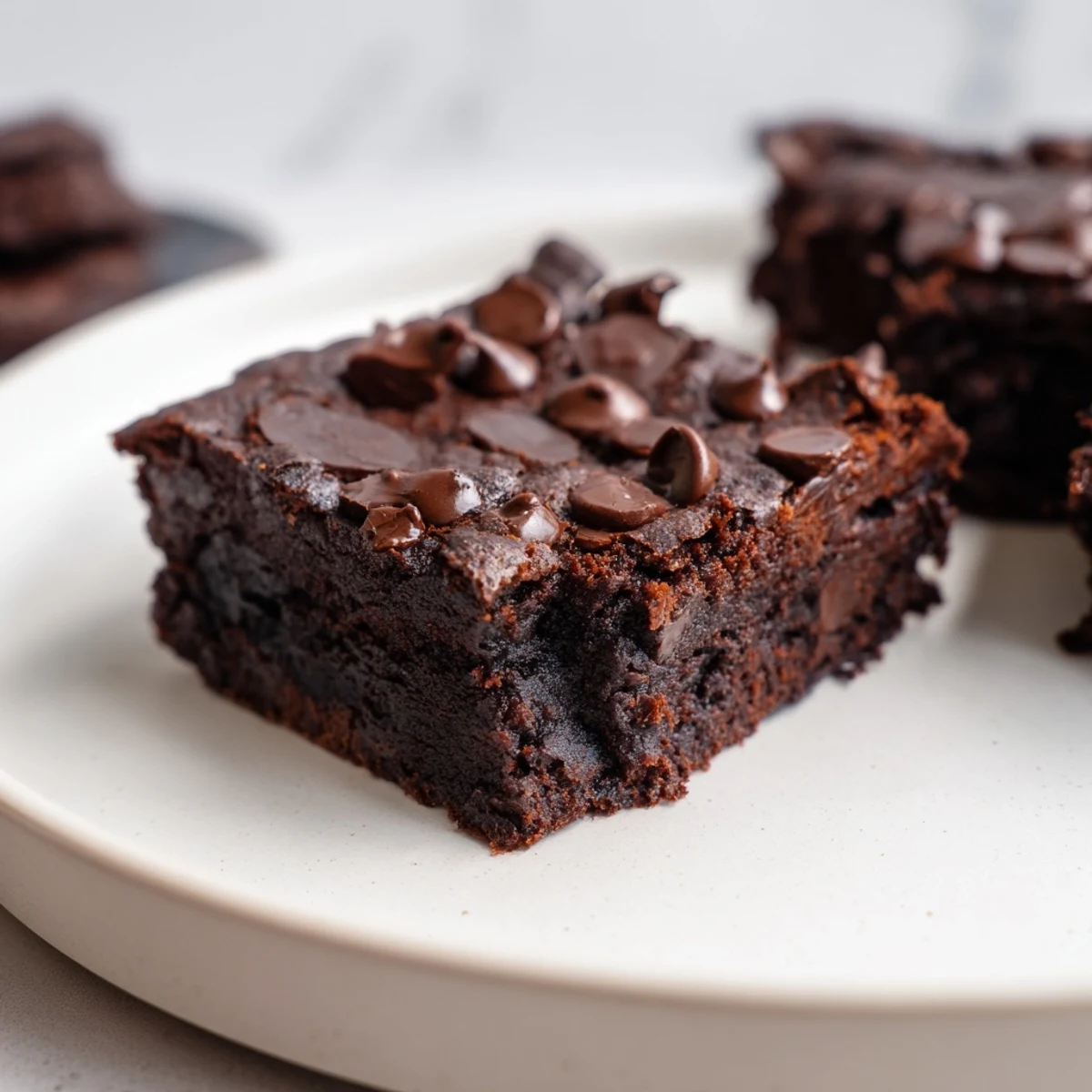 Square of gluten-free black bean brownies, showcasing a soft center and a lovely, dark hue.