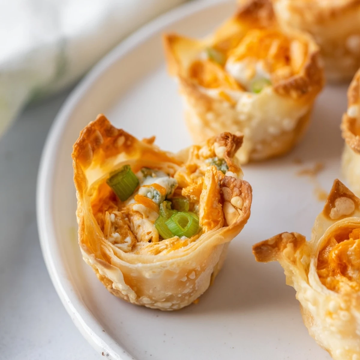 Golden-brown Buffalo Chicken Dip Pinwheel Wonton appetizers, crispy and ready for dipping in ranch.