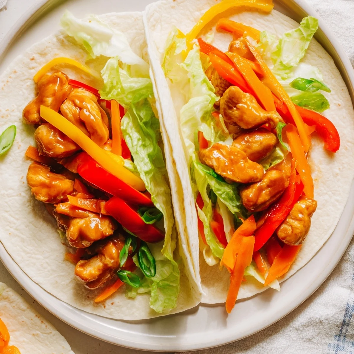 Freshly made Teriyaki Chicken Wrap, showcasing the juicy chicken and colorful vegetables nestled inside the tortilla.