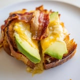 Savor the Avocado BLT Grilled Cheese, with creamy avocado slices and fresh tomato peeking from between golden, crunchy bread.  