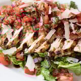 Bright and zesty Bruschetta Chicken Salad featuring juicy grilled chicken, diced tomatoes, fresh basil, and shaved Parmesan on a bed of greens.