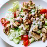 A vibrant bowl of Jalapeño Ranch Chicken Salad features juicy chicken, fresh veggies, and a bold, spicy ranch drizzle.  