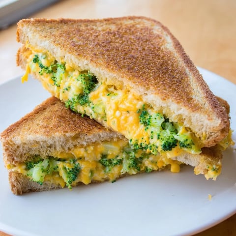 Golden-brown Air Fryer Broccoli Cheddar Stuffed Grilled Cheese, oozing with melted cheese and fresh broccoli.