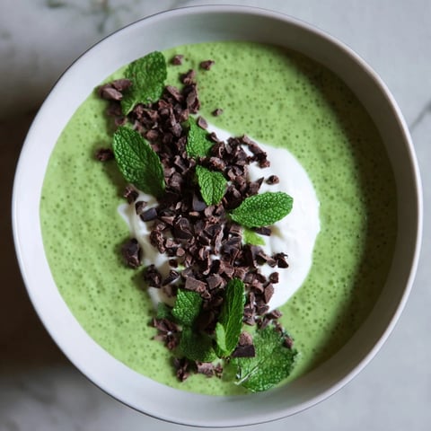 Grinch Green Mint Matcha Breakfast Chia Pudding, topped with yogurt, chocolate chips, and fresh mint on display.