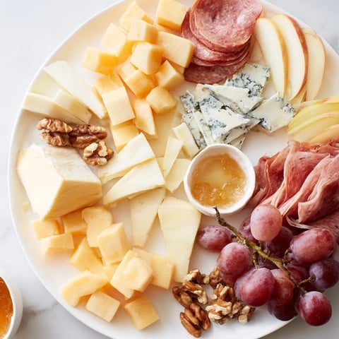A beautifully arranged Moonlight Picnic Board, showcasing assorted cheeses, meats, fruits, and crackers.
