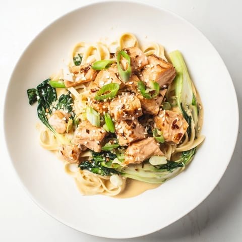 Creamy miso butter salmon pasta, served with vibrant bok choy and fresh scallions, is ready to savor.