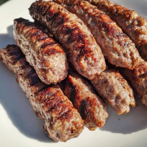 Golden-brown cooked Romanian mici sausages ready to serve, a flavorful street food favorite.