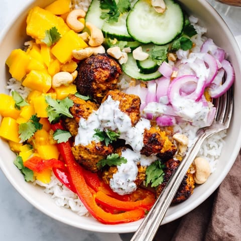 Imagine vibrant Mango Masala Chicken Tidy Bowls ready to eat, topped with fresh salad.
