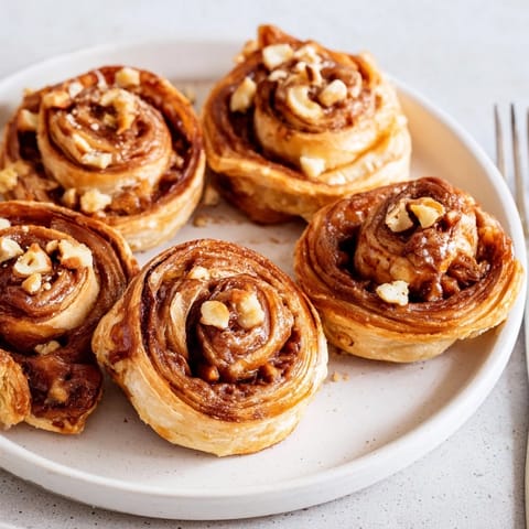 Freshly baked caramel apple Nutella pinwheels, flaky pastry filled with sweet flavors.  