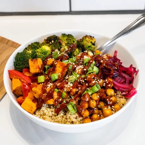 Colorful grain bowls featuring chickpeas and sweet potatoes, drizzled with gochujang-maple sauce.  