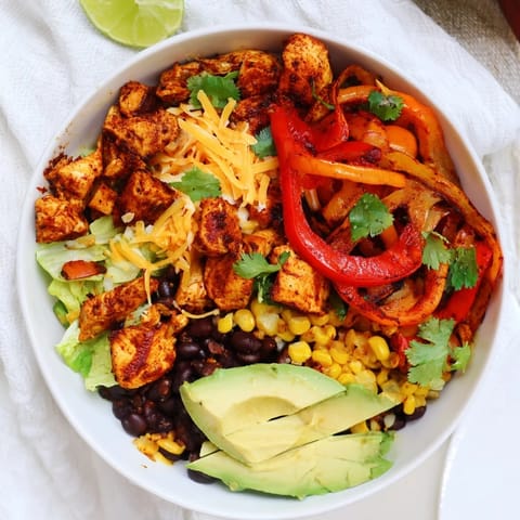 A close-up of a delightful Sheet Pan Chicken Burrito Bowl, brimming with fresh toppings and flavorful chicken.