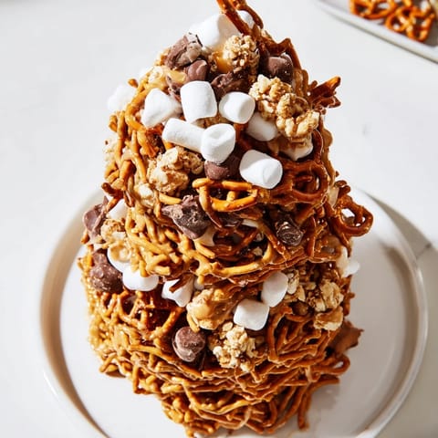 Vibrant photo of a finished haystack candy tower, layered with pretzels and peanut butter.