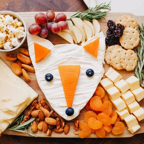 This delicious Whimsical Fox Fall Treat Board features a goat cheese fox with vibrant fall-colored treats.