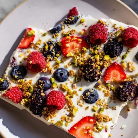 Cool, creamy frozen fruit yogurt bark layered with sweet berries and ready to be broken into pieces.