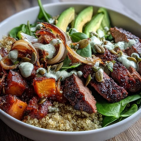 Smoky seared steak strips over a bed of vibrant greens and quinoa, topped with caramelized butternut squash cubes and pepitas.
