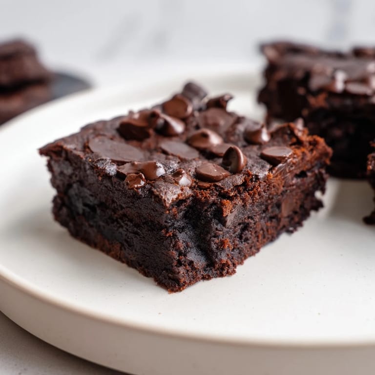 Square of gluten-free black bean brownies, showcasing a soft center and a lovely, dark hue.