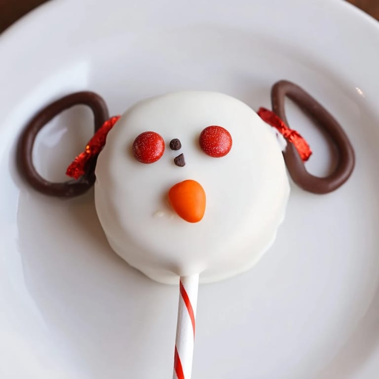 These easy, no-bake Budget-Friendly Oreo Snowman Pops showcase chocolate cookies dipped in white chocolate.
