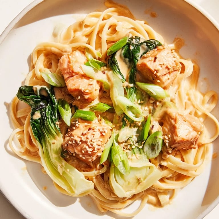 Tender salmon and al dente pasta smothered in rich miso butter sauce, a delicious fusion recipe.